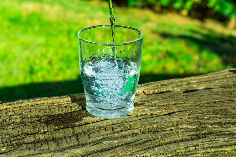 Process of pouring pure clear water into a glass from top, woode Signs You Aren’t Drinking Enough Water